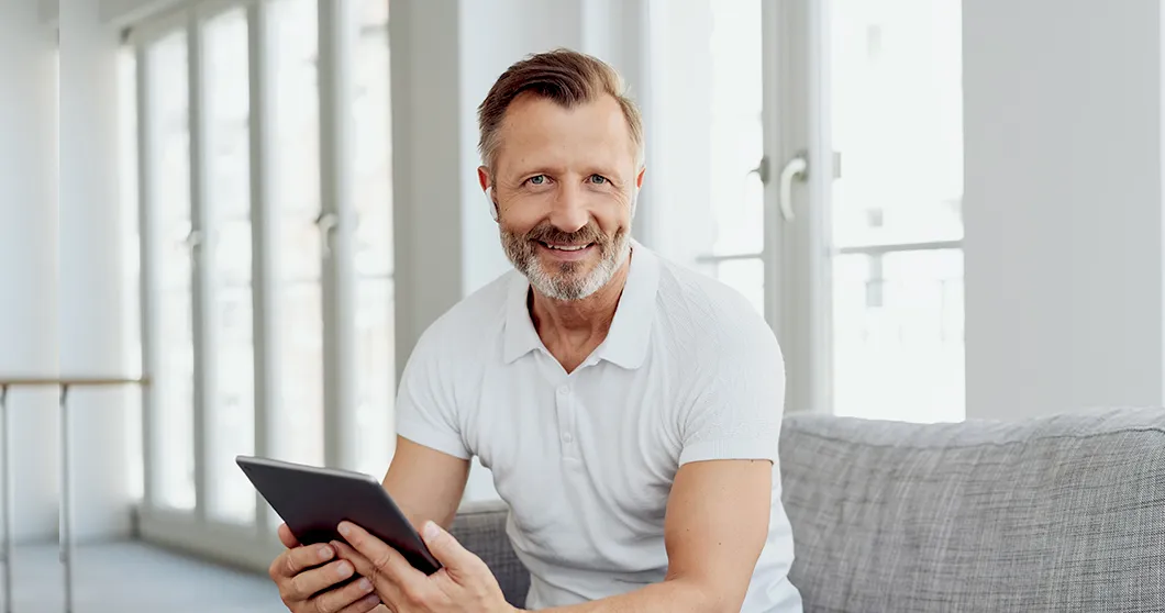 Hombre sonriendo con un tablet en la mano